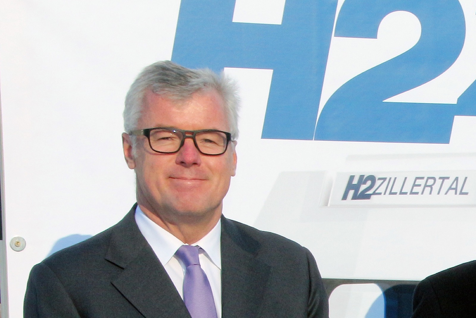 Helmut Schreiner vor dem Banner der Wasserstoff-Modellregion H2 Zillertal